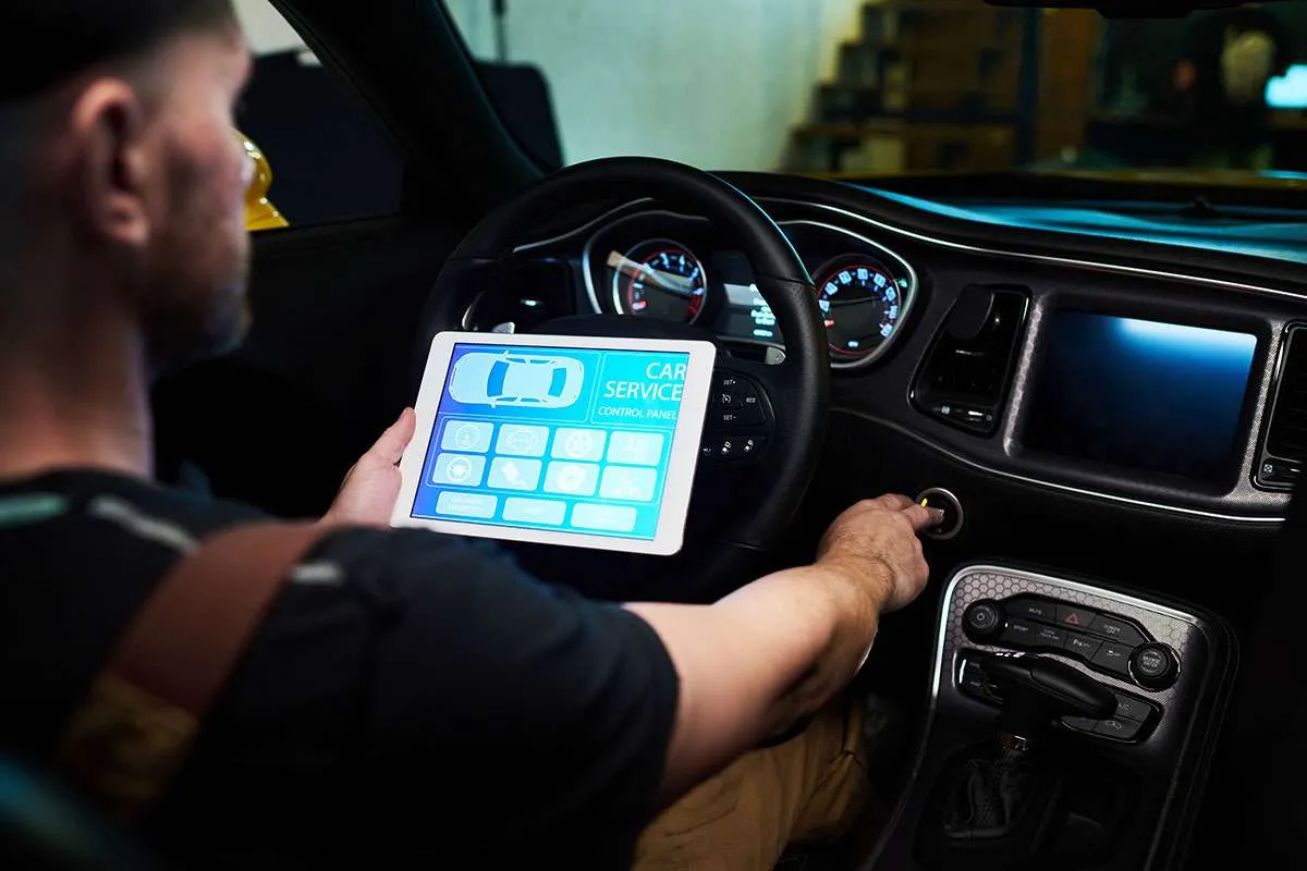 GettyImages-882354884-15435481-1 Man using digital car diagnostic tool while driving.
